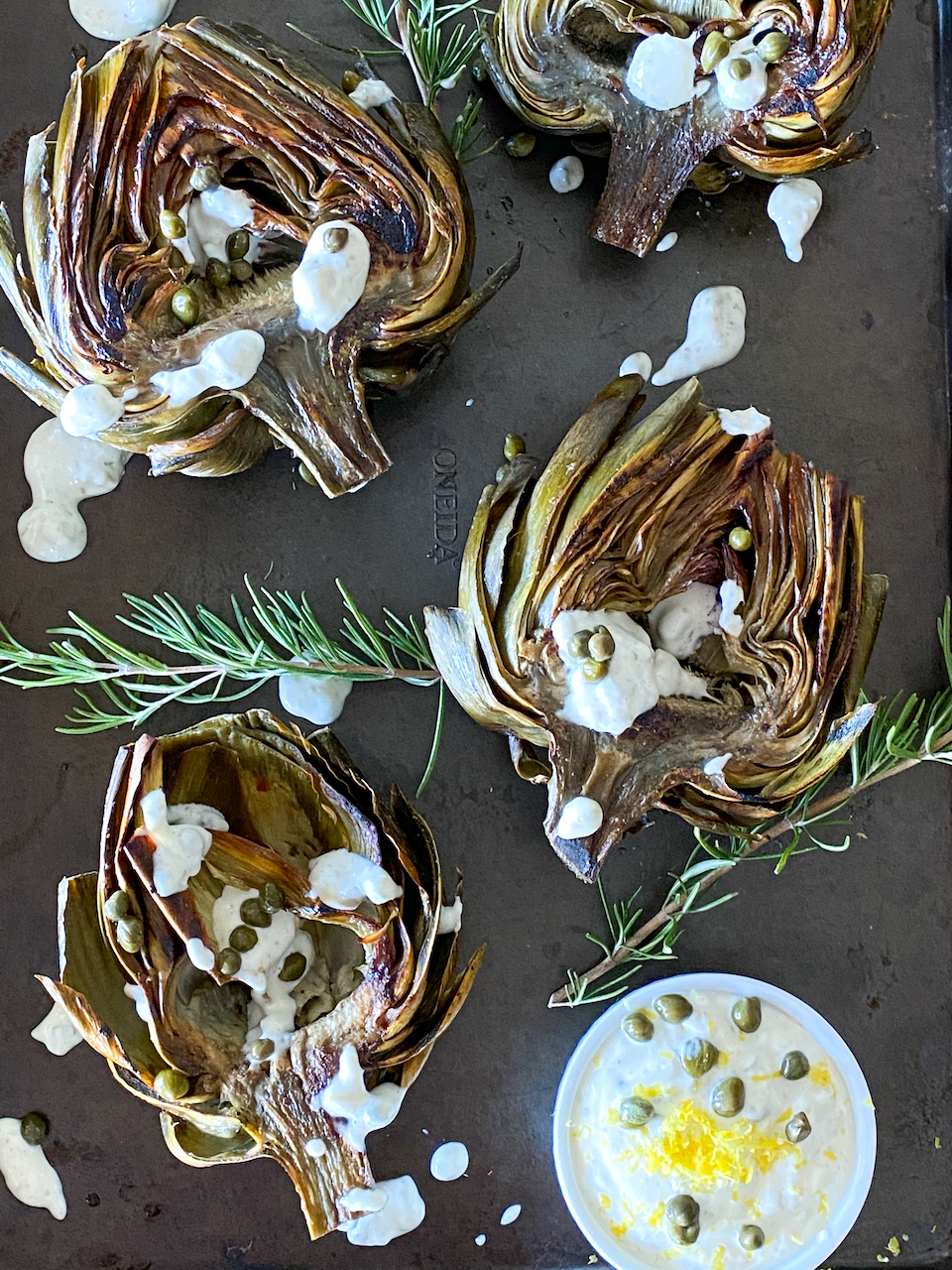 Flavorful and tender artichoke leaves and heart that are dipped in a lemony garlic sauce.  Roasted artichokes + lemon caper aioli makes for a mind-blowing side dish.